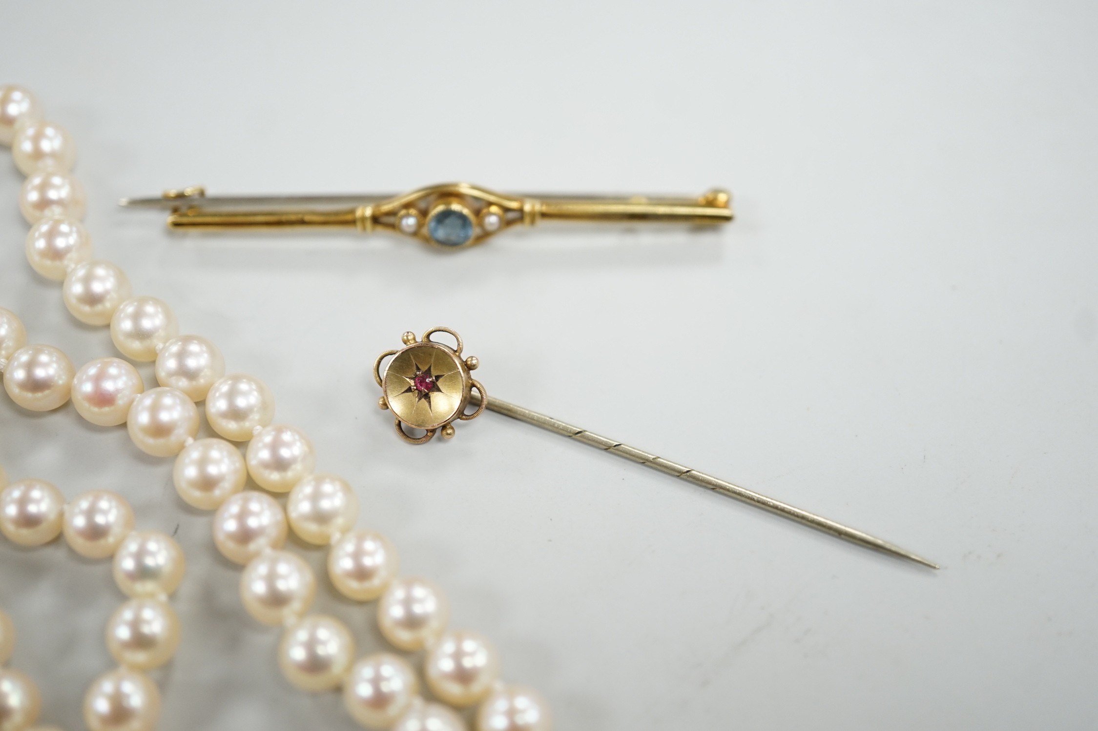 A single strand cultured pearl necklace, with 9ct gold clasp, 46cm, together with a yellow metal and ruby stick pin and a similar gem set bar brooch.